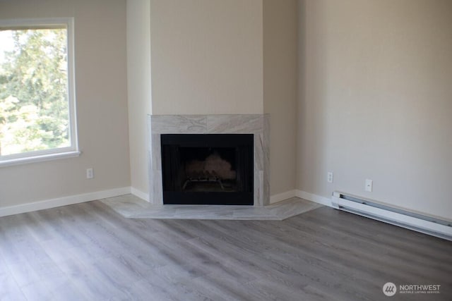 2611 NE 4th St Unit 234, Renton, WA 98056 - unfurnished living room featuring a fireplace, wood finished floors, a baseboard heating unit, and baseboards