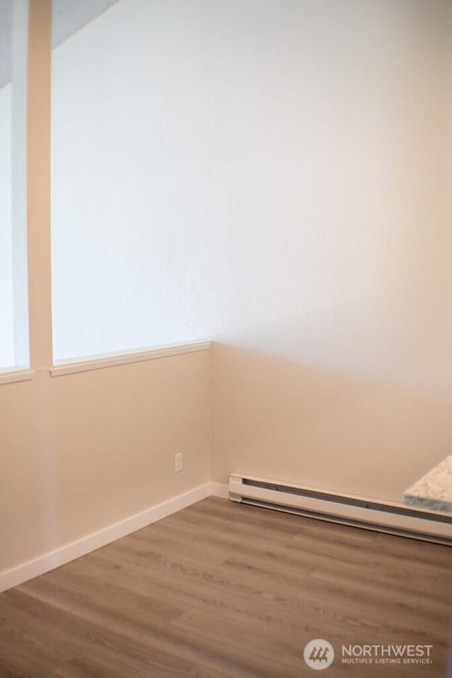 2611 NE 4th St Unit 234, Renton, WA 98056 - spare room with a baseboard heating unit, wood finished floors, and baseboards