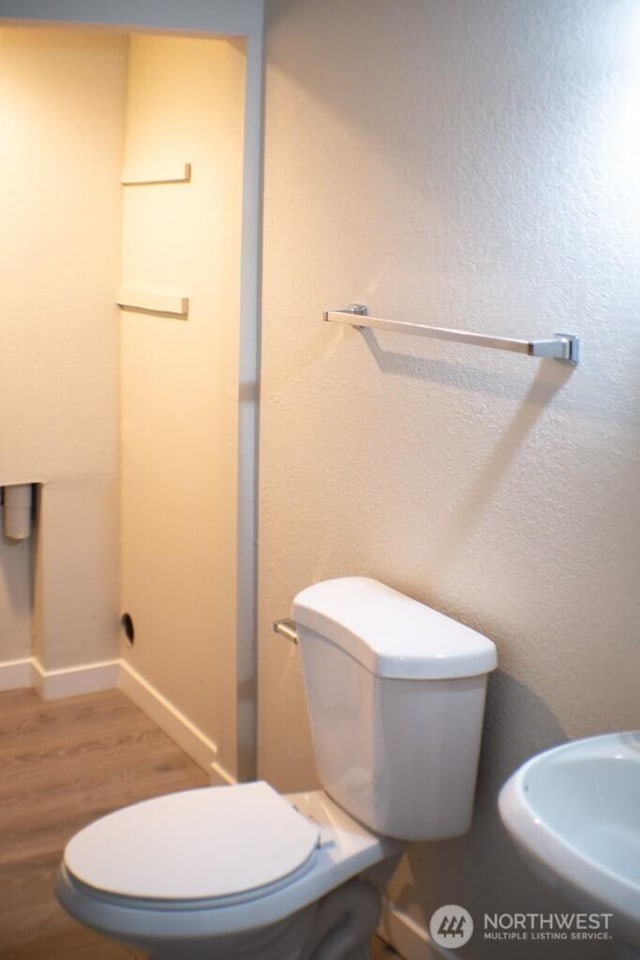 2611 NE 4th St Unit 234, Renton, WA 98056 - bathroom with wood finished floors, toilet, baseboards, and a sink