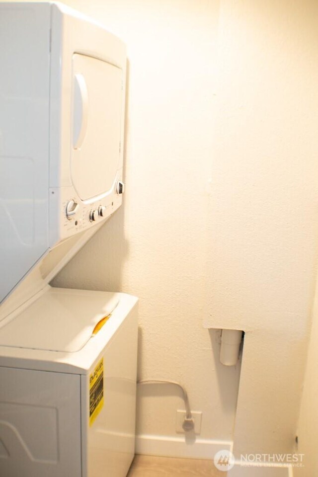 2611 NE 4th St Unit 234, Renton, WA 98056 - laundry area featuring stacked washer and clothes dryer and baseboards
