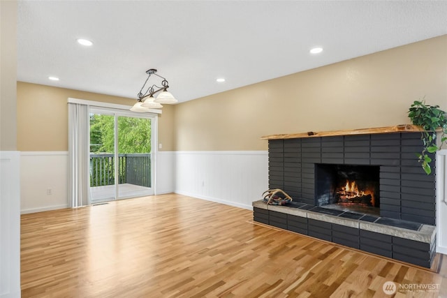 104 Hawthorn Ln, Shelton, WA 98584 - unfurnished living room featuring wainscoting, a tile fireplace, wood finished floors, and recessed lighting