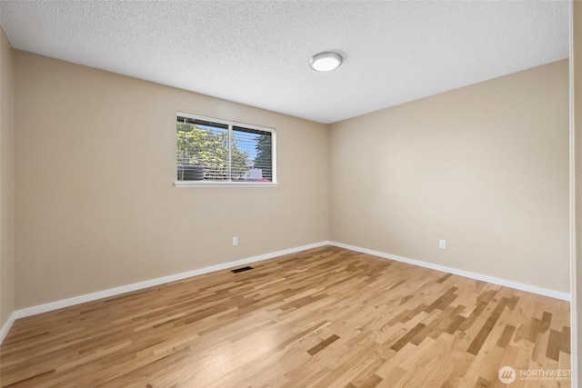 104 Hawthorn Ln, Shelton, WA 98584 - empty room with light wood finished floors, baseboards, and a textured ceiling