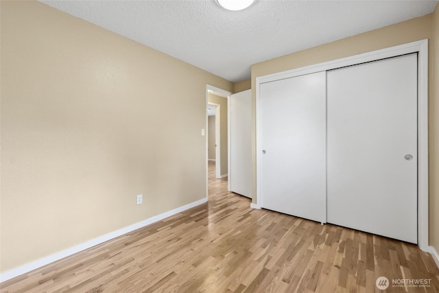 104 Hawthorn Ln, Shelton, WA 98584 - unfurnished bedroom featuring light wood-style floors, baseboards, a closet, and a textured ceiling