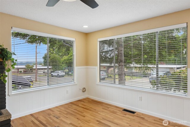 104 Hawthorn Ln, Shelton, WA 98584 - spare room featuring plenty of natural light, wood finished floors, ceiling fan, a textured ceiling, and wainscoting