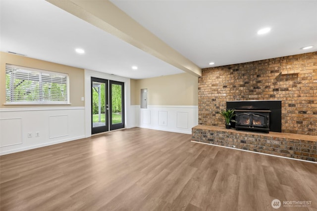 104 Hawthorn Ln, Shelton, WA 98584 - unfurnished living room with wainscoting, wood finished floors, recessed lighting, a decorative wall, and a wood stove