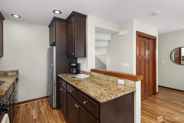 9521 8th Ave NW Unit A, Seattle, WA 98117 - kitchen featuring light wood-style flooring, dark brown cabinets, baseboards, light stone counters, and recessed lighting