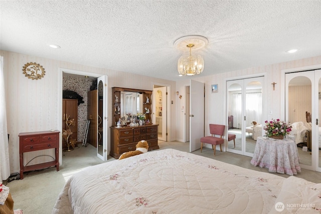 515 N Clark Rd, Moses Lake, WA 98837 - bedroom with wallpapered walls, a textured ceiling, carpet, two closets, and a chandelier