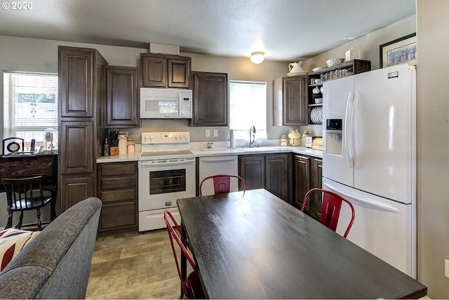 1693 N Sheperd Rd Unit 14, Washougal, WA 98671 - kitchen featuring white appliances, dark brown cabinetry, open shelves, a sink, and light countertops