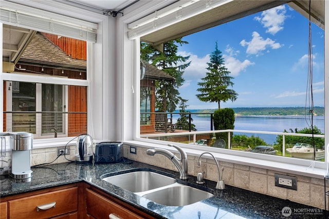 31111 53rd Ave SW, Federal Way, WA 98023 - kitchen featuring a sink, a water view, dark stone counters, and brown cabinets