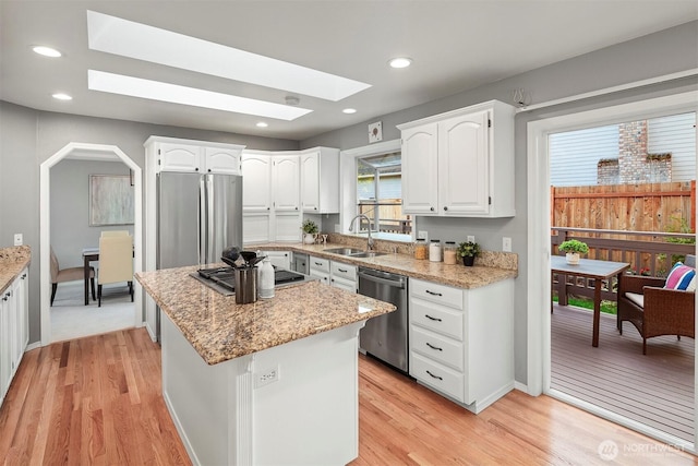 6513 156th Ave SE, Bellevue, WA 98006 - kitchen featuring stainless steel appliances, a sink, a skylight, white cabinetry, and recessed lighting