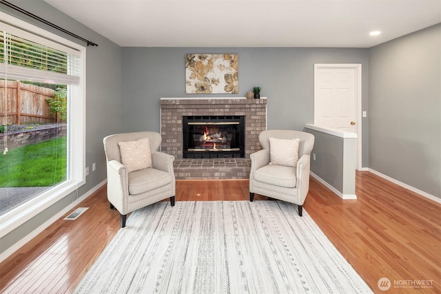 6513 156th Ave SE, Bellevue, WA 98006 - living area with wood finished floors, a brick fireplace, and baseboards