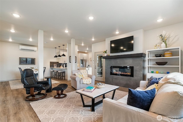 4260 Creston Way, Bellingham, WA 98226 - living room with wood finished floors, a wall mounted AC, a fireplace, recessed lighting, and baseboards