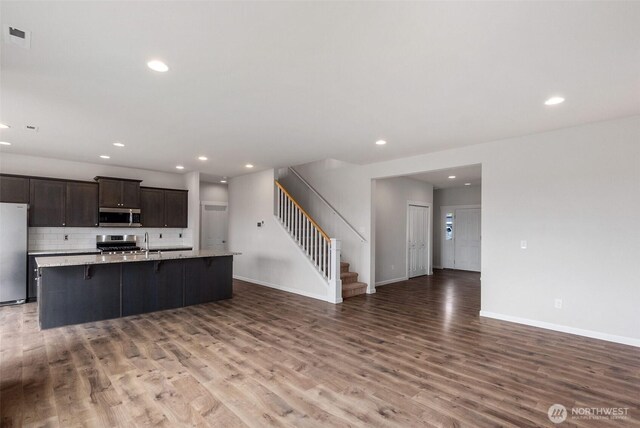 2719 Fiddleback St NE, Lacey, WA 98516 - kitchen featuring stainless steel appliances, light wood-style floors, light countertops, a breakfast bar, and recessed lighting
