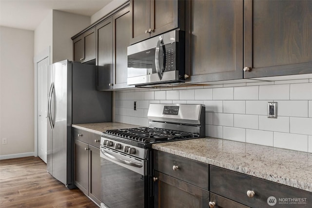 2719 Fiddleback St NE, Lacey, WA 98516 - kitchen featuring stainless steel appliances, dark brown cabinetry, baseboards, dark wood-style flooring, and backsplash