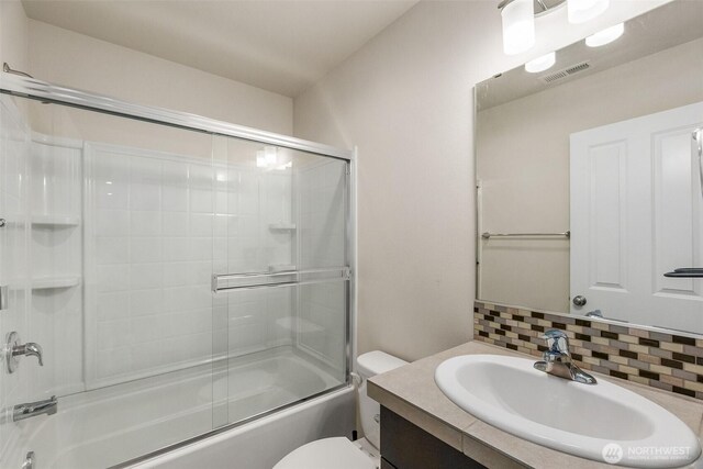 2719 Fiddleback St NE, Lacey, WA 98516 - bathroom featuring decorative backsplash, vanity, toilet, and enclosed tub / shower combo