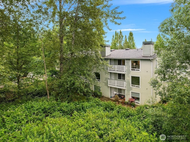 12315 NE 97th St Unit G, Kirkland, WA 98033 - rear view of house with a balcony, a chimney, and a shingled roof