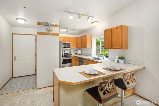 12315 NE 97th St Unit G, Kirkland, WA 98033 - kitchen featuring appliances with stainless steel finishes, a peninsula, light countertops, and track lighting