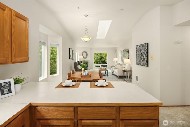 12315 NE 97th St Unit G, Kirkland, WA 98033 - kitchen featuring open floor plan, a peninsula, a skylight, light countertops, and light colored carpet