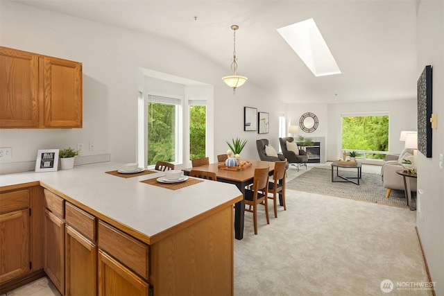 12315 NE 97th St Unit G, Kirkland, WA 98033 - kitchen featuring a skylight, vaulted ceiling, a peninsula, healthy amount of natural light, and light countertops