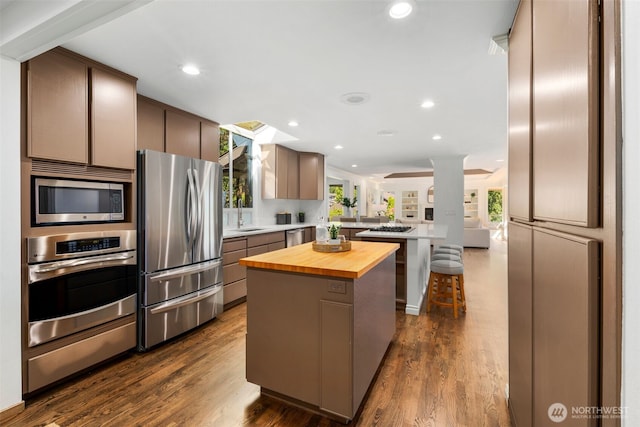 16939 SE 39th St, Bellevue, WA 98008 - kitchen with appliances with stainless steel finishes, a peninsula, butcher block counters, recessed lighting, and a kitchen island