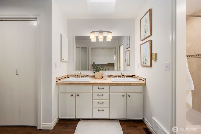 16939 SE 39th St, Bellevue, WA 98008 - bathroom featuring wood finished floors, double vanity, and baseboards