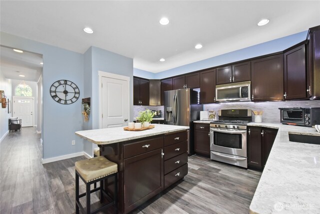 23804 17th Pl W, Bothell, WA 98021 - kitchen with appliances with stainless steel finishes, backsplash, dark brown cabinetry, a center island, and recessed lighting