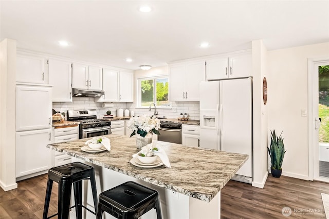 404 Veralene Way SW, Everett, WA 98203 - kitchen with stainless steel appliances, under cabinet range hood, white cabinets, tasteful backsplash, and recessed lighting