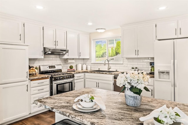 404 Veralene Way SW, Everett, WA 98203 - kitchen with stainless steel gas stove, under cabinet range hood, white refrigerator with ice dispenser, a sink, and white cabinetry