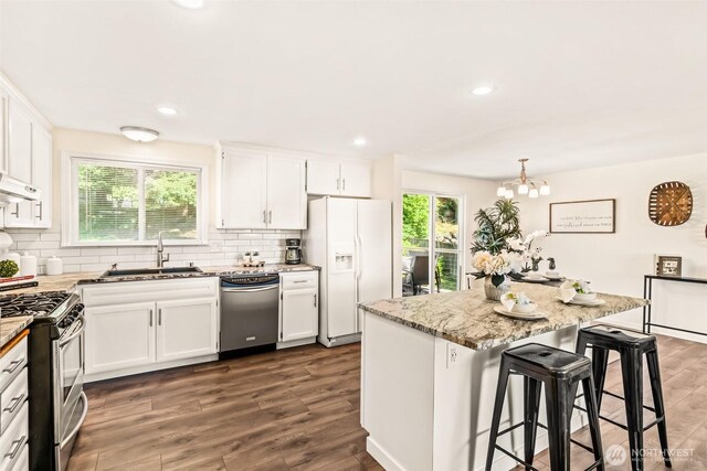 404 Veralene Way SW, Everett, WA 98203 - kitchen featuring stainless steel appliances, a sink, decorative backsplash, white cabinets, and light stone counters