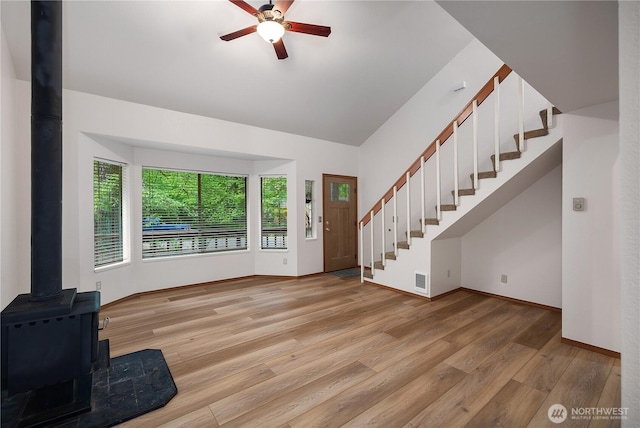 7549 Siskin Dr SE, Olympia, WA 98513 - foyer featuring stairs, light wood-type flooring, a wood stove, a ceiling fan, and vaulted ceiling
