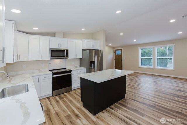 270 Granat St, Port Orchard, WA 98366 - kitchen with appliances with stainless steel finishes, a sink, light wood-type flooring, white cabinetry, and a center island