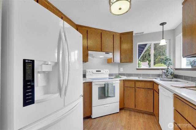 14426 55th Ave SE, Everett, WA 98208 - kitchen with white appliances, under cabinet range hood, light countertops, and brown cabinets