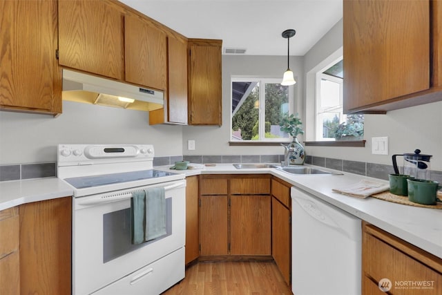 14426 55th Ave SE, Everett, WA 98208 - kitchen featuring white appliances, under cabinet range hood, a sink, and brown cabinets