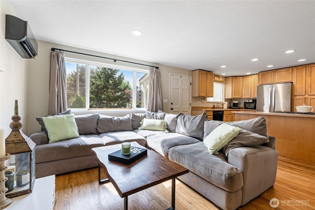 26600 Weaver Ave NW, Poulsbo, WA 98370 - living area with a wall mounted AC, plenty of natural light, recessed lighting, light wood-type flooring, and a textured ceiling