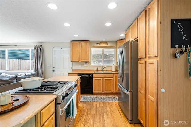 26600 Weaver Ave NW, Poulsbo, WA 98370 - kitchen with appliances with stainless steel finishes, light wood-style flooring, light countertops, healthy amount of natural light, and recessed lighting