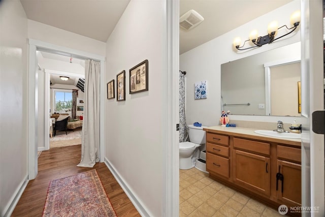 5695 Meadow View Dr, Ferndale, WA 98248 - bathroom featuring toilet, vanity, wood finished floors, and baseboards