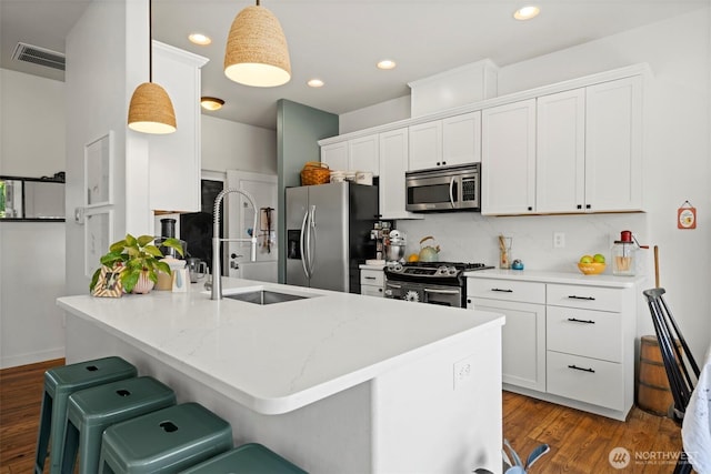 5695 Meadow View Dr, Ferndale, WA 98248 - kitchen featuring appliances with stainless steel finishes, a sink, white cabinetry, a peninsula, and wood finished floors