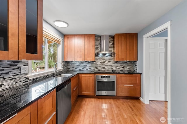 14208 NE 73rd St, Redmond, WA 98052 - kitchen featuring stainless steel appliances, wall chimney exhaust hood, a sink, dark stone countertops, and light wood finished floors