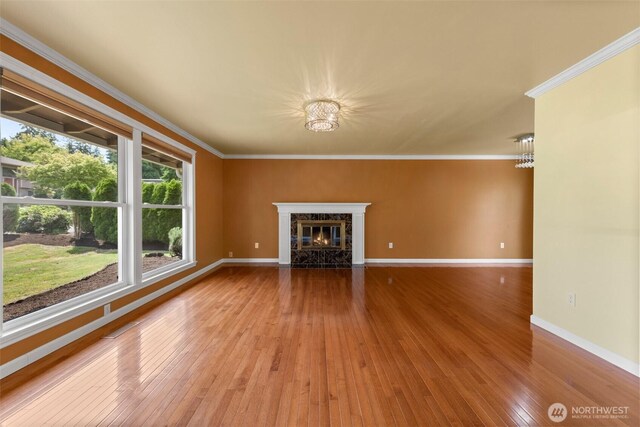 14208 NE 73rd St, Redmond, WA 98052 - unfurnished living room featuring wood-type flooring, ornamental molding, baseboards, a high end fireplace, and a chandelier