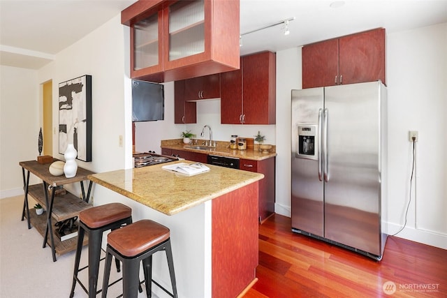 1105 Spring St Unit 712, Seattle, WA 98104 - kitchen with stainless steel refrigerator with ice dispenser, a breakfast bar area, light wood-style floors, glass insert cabinets, and light stone counters