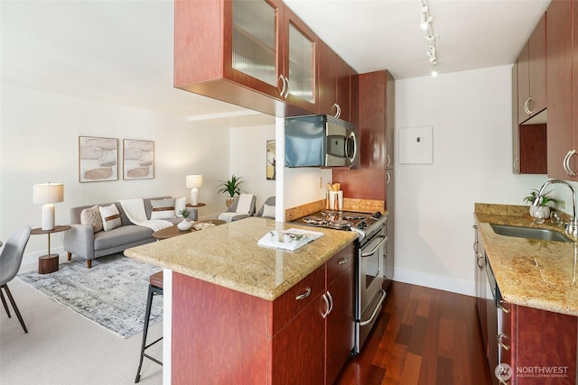 1105 Spring St Unit 712, Seattle, WA 98104 - kitchen with stainless steel appliances, a breakfast bar, light stone counters, glass insert cabinets, and open floor plan