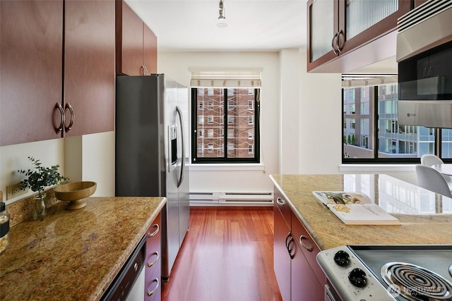 1105 Spring St Unit 712, Seattle, WA 98104 - kitchen featuring baseboard heating, appliances with stainless steel finishes, dark wood finished floors, glass insert cabinets, and light stone counters