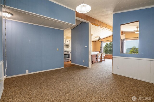 7515 Sunset Dr, Blaine, WA 98230 - carpeted spare room with lofted ceiling, ceiling fan, wood walls, and baseboards