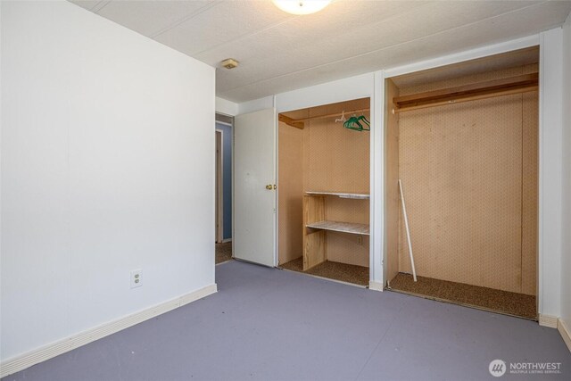 7515 Sunset Dr, Blaine, WA 98230 - unfurnished bedroom featuring finished concrete flooring and multiple closets