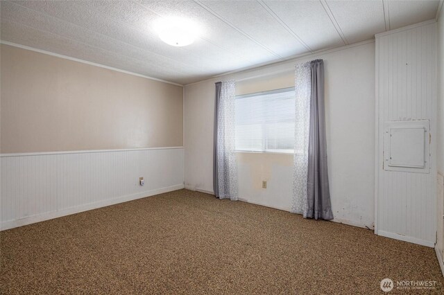 7515 Sunset Dr, Blaine, WA 98230 - carpeted spare room with ornamental molding, electric panel, wainscoting, and wooden walls