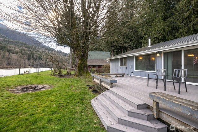 8789 Cedar Ct, Sedro Woolley, WA 98284 - view of yard with a fire pit, a deck with mountain view, and a forest view
