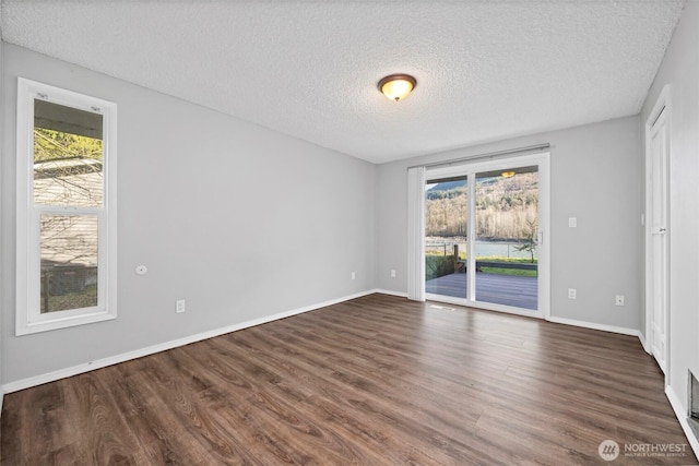 8789 Cedar Ct, Sedro Woolley, WA 98284 - empty room with a textured ceiling, dark wood finished floors, and baseboards