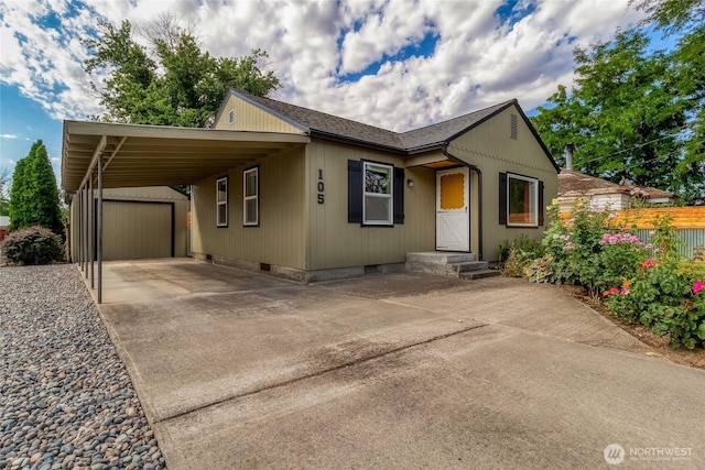 105 York St, Walla Walla, WA 99362 - view of front facade with concrete driveway, an attached carport, an outdoor structure, and crawl space
