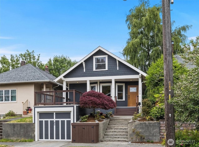 1218 NE 69th St, Seattle, WA 98115 - view of front facade with stairway, driveway, covered porch, and an attached garage