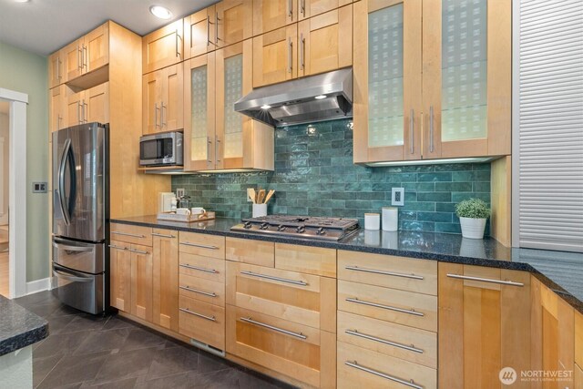1218 NE 69th St, Seattle, WA 98115 - kitchen with appliances with stainless steel finishes, under cabinet range hood, tasteful backsplash, light brown cabinetry, and glass insert cabinets